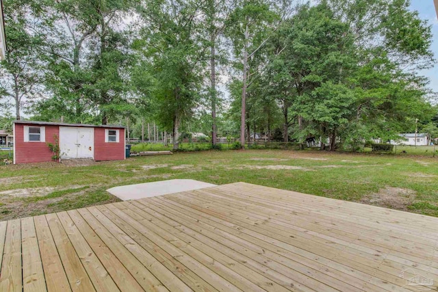 deck featuring an outdoor structure, view of scattered trees, and a shed