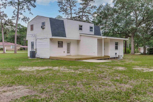 rear view of property with a deck, roof with shingles, a lawn, a gambrel roof, and central air condition unit