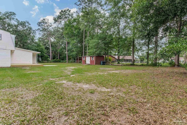 view of green lawn with a storage shed, an outdoor structure, and view of scattered trees