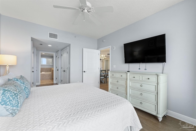 bedroom featuring connected bathroom, a textured ceiling, hardwood / wood-style flooring, and ceiling fan