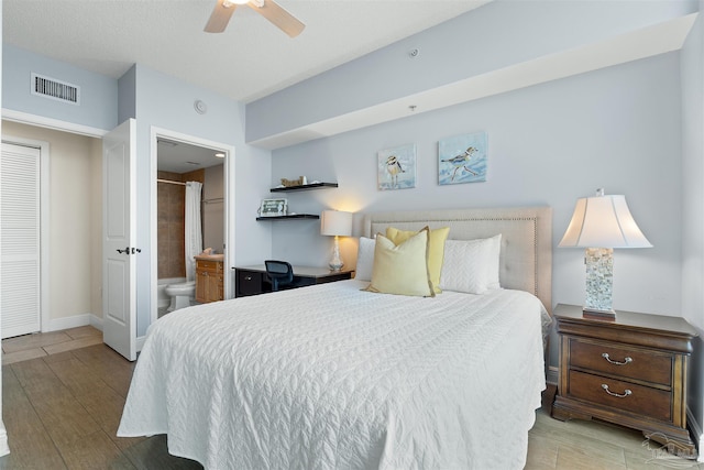 bedroom featuring ceiling fan, light hardwood / wood-style floors, and ensuite bath