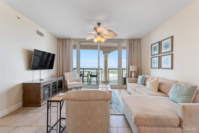 living room featuring ceiling fan, a textured ceiling, and light tile patterned floors