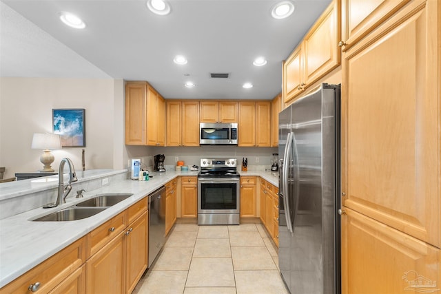 kitchen featuring sink, appliances with stainless steel finishes, light brown cabinetry, light stone countertops, and light tile patterned floors