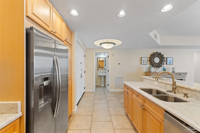 kitchen with light tile patterned flooring, light brown cabinetry, sink, and appliances with stainless steel finishes