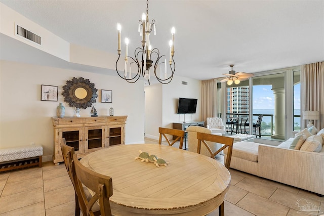 tiled dining room featuring ceiling fan with notable chandelier