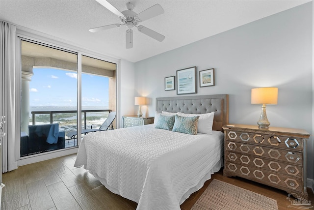 bedroom with hardwood / wood-style flooring, floor to ceiling windows, ceiling fan, a textured ceiling, and access to exterior