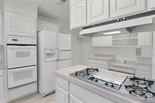 20 Magnolia Ave, Shalimar, FL 32579 - kitchen with white appliances, premium range hood, white cabinets, light wood-style floors, and open shelves