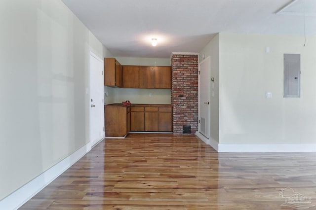 20 Magnolia Ave, Shalimar, FL 32579 - kitchen with electric panel, brown cabinets, and light wood-style floors