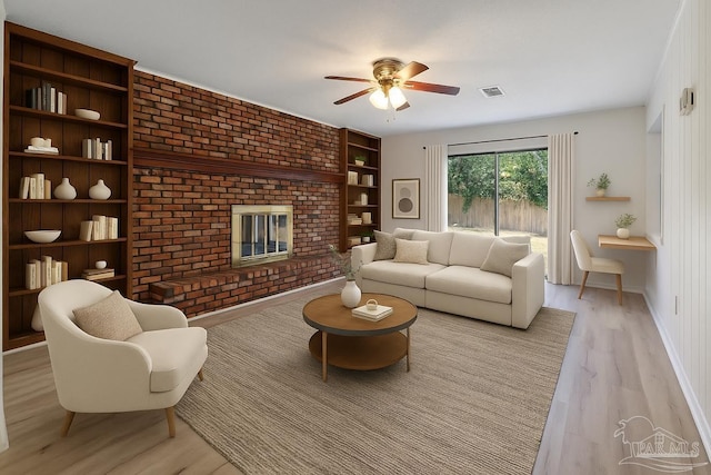 20 Magnolia Ave, Shalimar, FL 32579 - living area featuring light wood-type flooring, a ceiling fan, built in shelves, and a brick fireplace