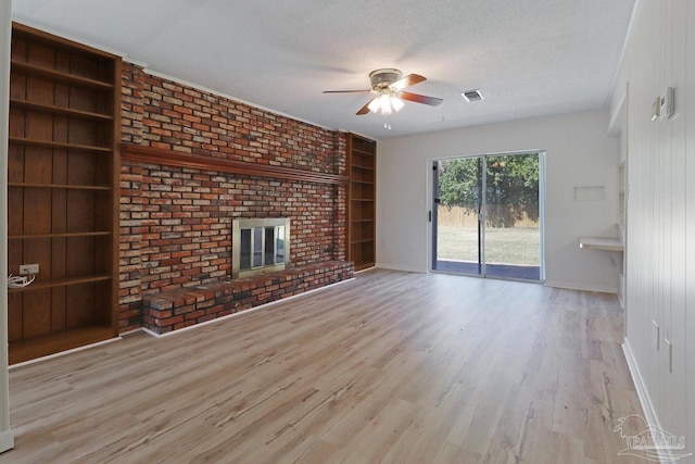 20 Magnolia Ave, Shalimar, FL 32579 - unfurnished living room with ceiling fan, built in shelves, a brick fireplace, wood finished floors, and a textured ceiling