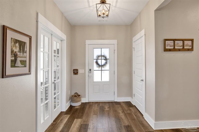 entrance foyer with french doors, dark hardwood / wood-style floors, and a notable chandelier