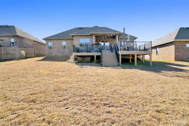 rear view of property with a yard and a wooden deck