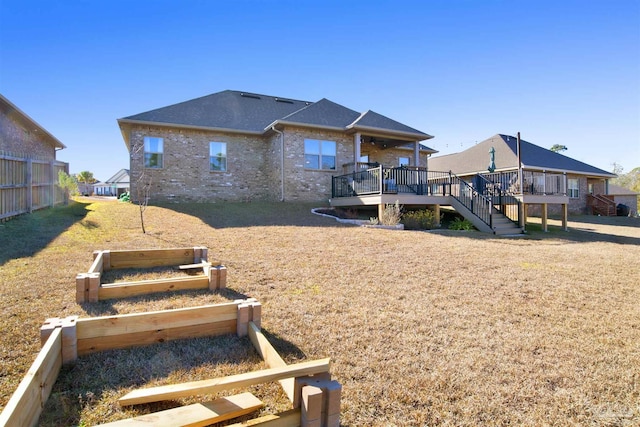 rear view of house with a deck and a yard