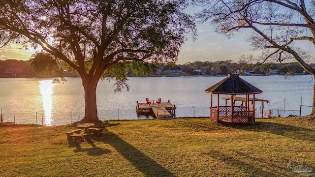 dock area with a water view, a yard, and a gazebo