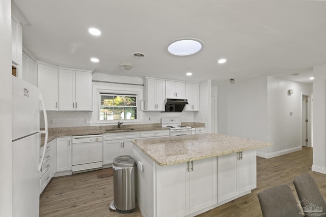 kitchen featuring white cabinetry, white appliances, light stone counters, and a kitchen island