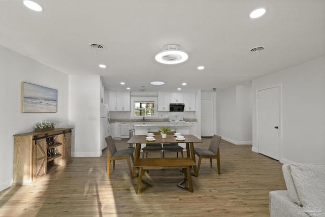 dining space with wood-type flooring