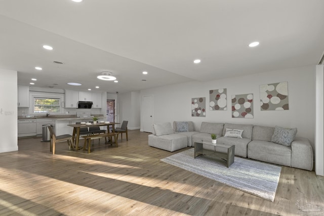 living room featuring sink and light hardwood / wood-style floors