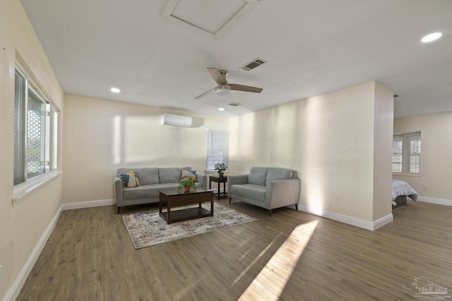 living room with ceiling fan, wood-type flooring, and a wall mounted AC