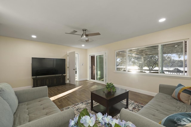 living room featuring dark wood-type flooring and ceiling fan