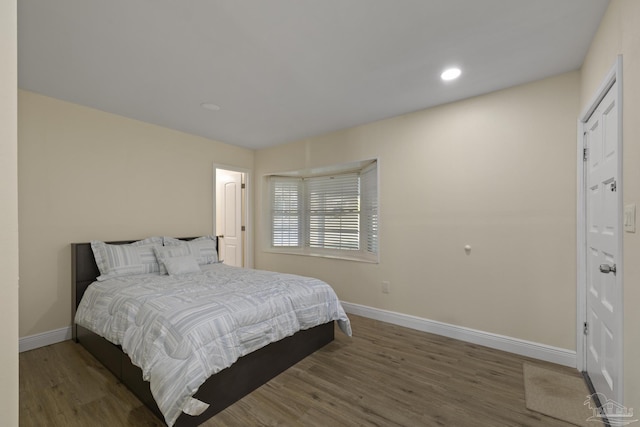 bedroom with dark hardwood / wood-style floors