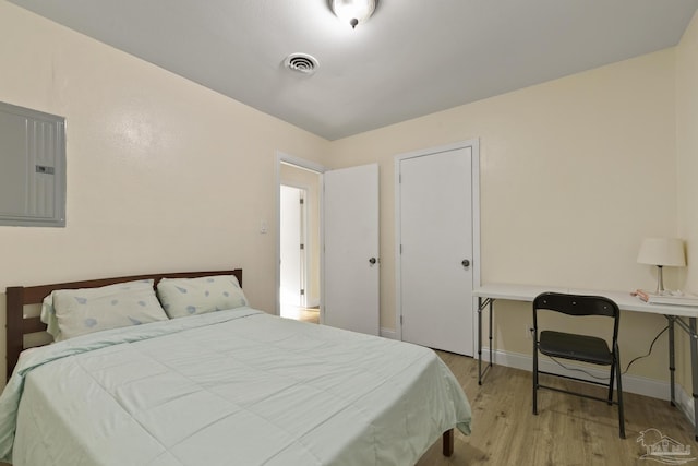 bedroom featuring light hardwood / wood-style floors and electric panel