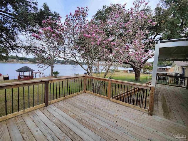 wooden terrace featuring a yard, a gazebo, and a water view