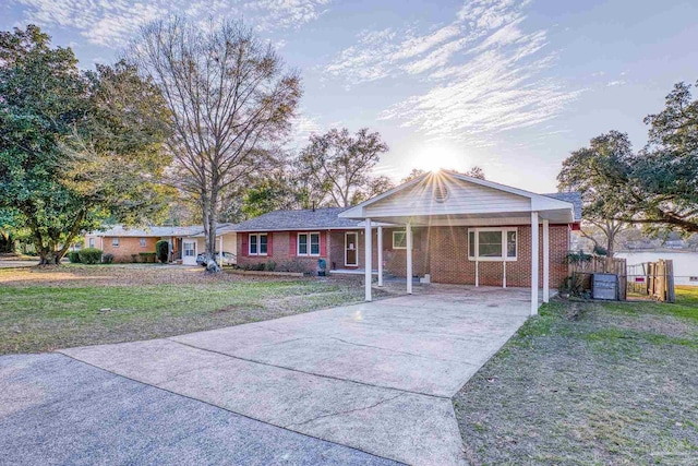 single story home with a front yard and a carport