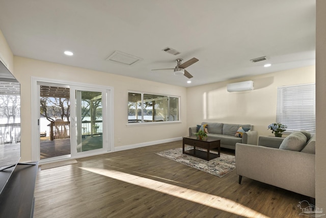 living room with dark hardwood / wood-style flooring, a wall mounted AC, and ceiling fan