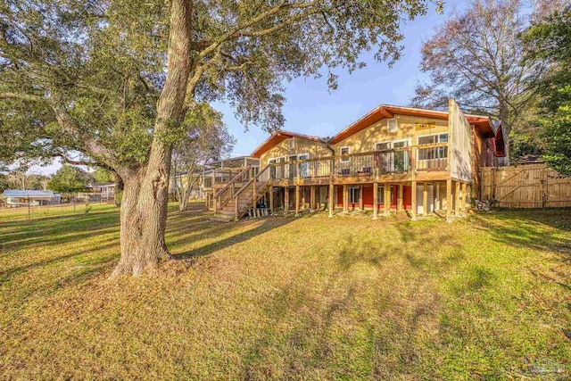 rear view of property featuring a wooden deck and a yard