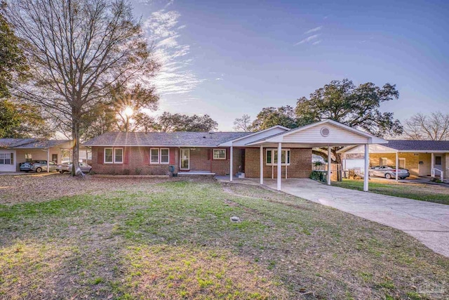 ranch-style house featuring a carport and a yard