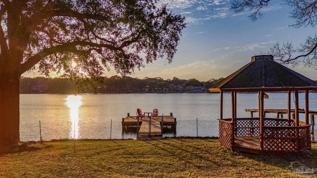 view of dock featuring a water view and a lawn