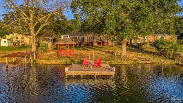 dock area featuring a gazebo, a water view, and a yard