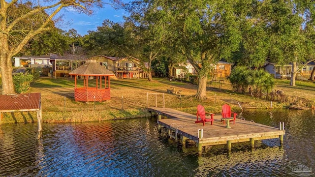 dock area featuring a gazebo, a water view, and a lawn