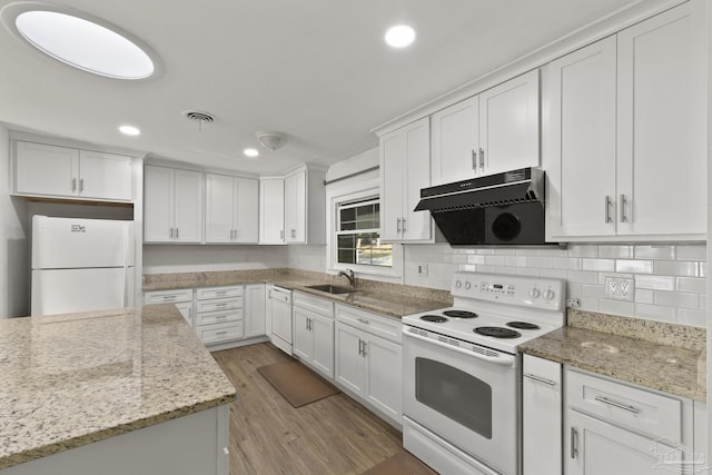 kitchen featuring white appliances, light stone countertops, sink, and white cabinets