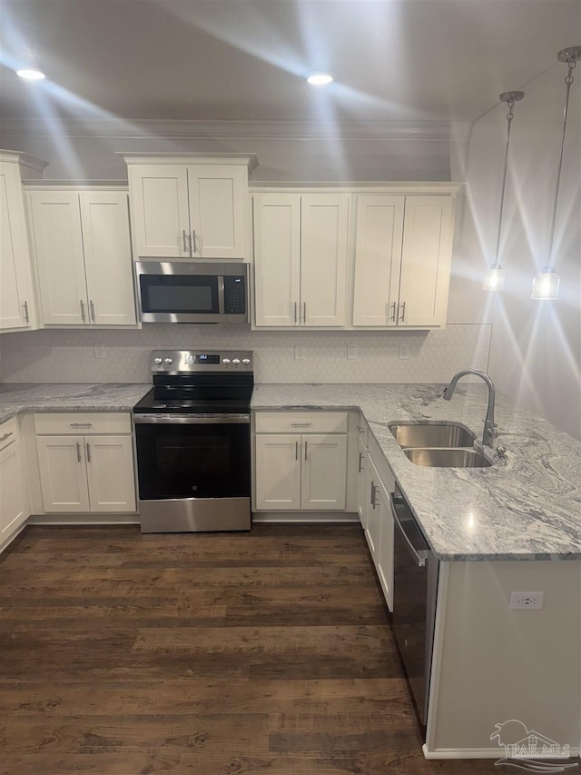 kitchen featuring stainless steel appliances, white cabinets, a sink, and a peninsula