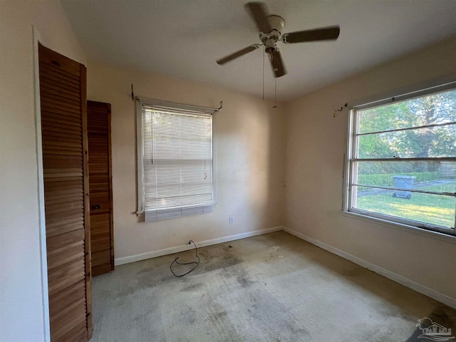 carpeted empty room featuring ceiling fan