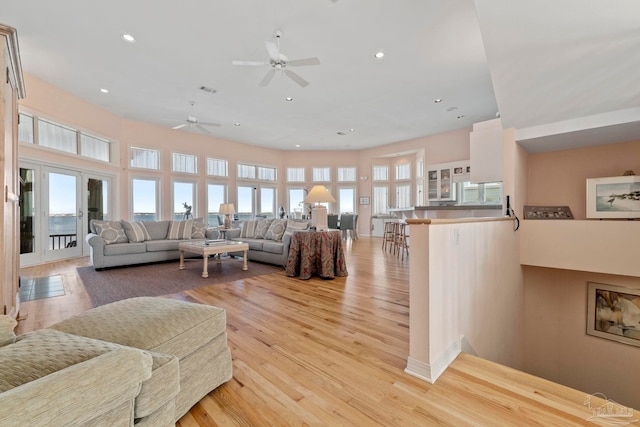 living room featuring a towering ceiling and light hardwood / wood-style floors