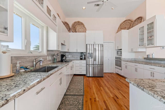 kitchen featuring stainless steel appliances, sink, white cabinets, and light hardwood / wood-style flooring