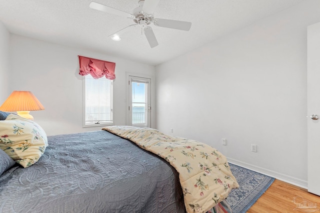 bedroom with hardwood / wood-style floors, a textured ceiling, and ceiling fan