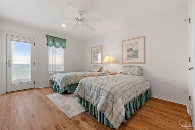 bedroom featuring a textured ceiling, wood-type flooring, and ceiling fan