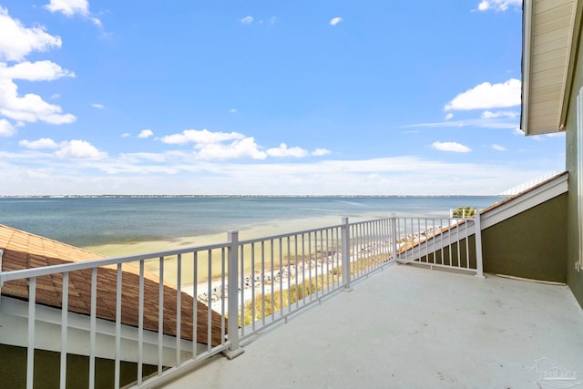 balcony featuring a view of the beach and a water view