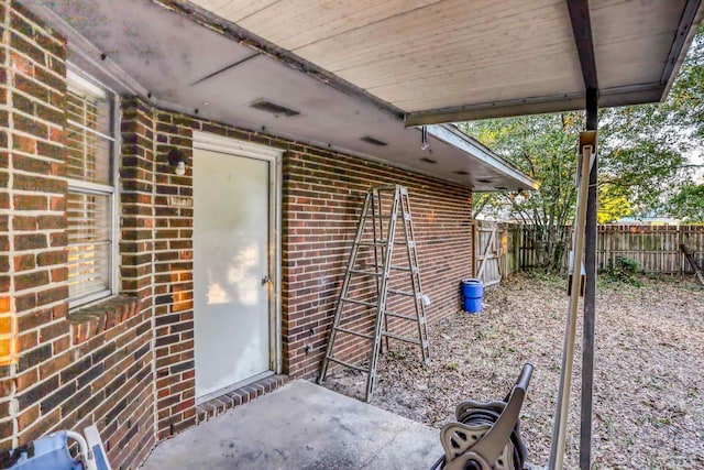 doorway to property with fence and brick siding