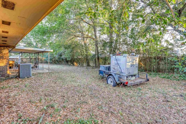 view of yard with central AC, a patio area, and a fenced backyard