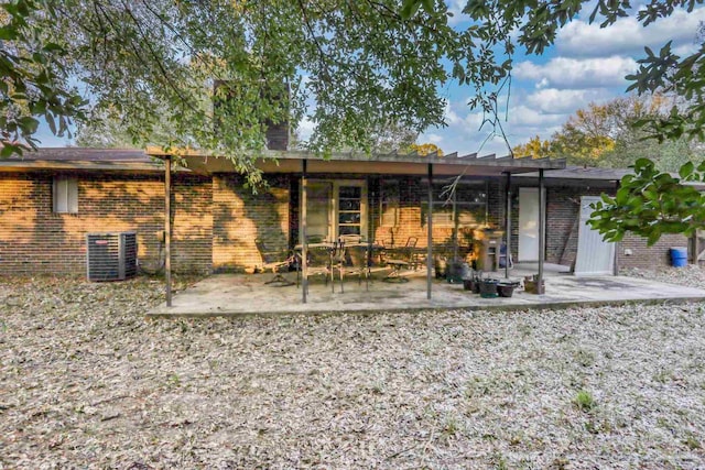 back of property with central air condition unit, a patio, and brick siding