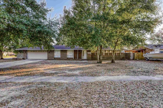 ranch-style house with a garage, driveway, and brick siding