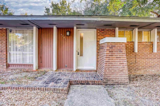 entrance to property featuring brick siding