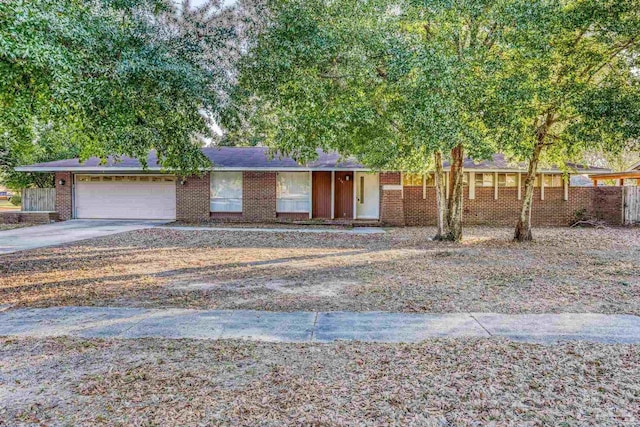 ranch-style house featuring a garage, concrete driveway, and brick siding