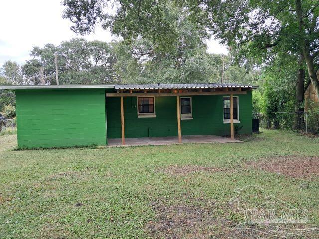 back of house with central air condition unit, a patio area, and a lawn