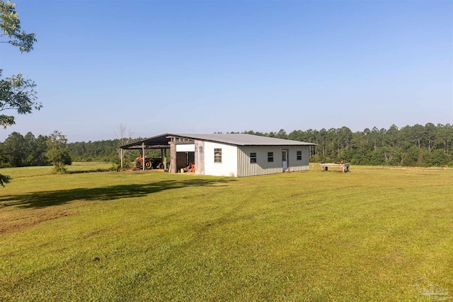 view of yard featuring a pole building, a carport, and an outbuilding