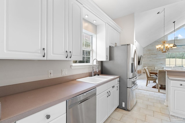 kitchen with decorative light fixtures, appliances with stainless steel finishes, white cabinetry, a sink, and plenty of natural light